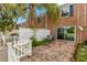 Private patio with hammock, enclosed by a white fence and lush greenery at 13696 Orange Sunset Dr, Tampa, FL 33618