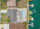 Overhead shot featuring a home with a pool, solar panels, boat dock, and canal-front living at 13704 Evelane Dr, Hudson, FL 34667