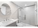 Bathroom featuring gray vanity, white countertop, round mirror, and glass enclosed shower at 13704 Evelane Dr, Hudson, FL 34667