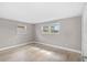 Empty bedroom featuring two windows and light laminate flooring at 13704 Evelane Dr, Hudson, FL 34667