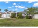 Charming single-story home featuring a well-maintained lawn, tropical landscaping, and a stylish dolphin accent at 13704 Evelane Dr, Hudson, FL 34667