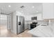 Modern kitchen featuring stainless steel appliances, white cabinets, and a white marble countertop at 13704 Evelane Dr, Hudson, FL 34667