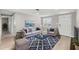 Stylishly furnished living room with modern decor, including a blue rug, gray sofa, and matching armchair at 13704 Evelane Dr, Hudson, FL 34667