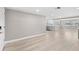 Bright and open living space with new flooring and gray walls, seamlessly leading to the kitchen area at 13704 Evelane Dr, Hudson, FL 34667