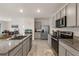 Modern kitchen featuring granite counters, stainless steel appliances, and ample gray cabinetry at 15959 Tuscany Hillside Rd, Odessa, FL 33556