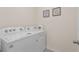 Bright laundry area showcasing a modern washer and dryer set with decorative wall art at 15959 Tuscany Hillside Rd, Odessa, FL 33556