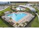 Aerial view of the community pool, featuring a large lap pool, a free form pool, covered seating and palm trees at 15959 Tuscany Hillside Rd, Odessa, FL 33556
