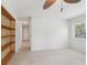 Bright bedroom with tile floors, a ceiling fan, and a built-in bookshelf for storage at 1605 W Dorchester Dr, Palm Harbor, FL 34684