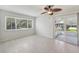 Comfortable bedroom featuring tile floors, a ceiling fan, and a sliding glass door to the outdoors at 1605 W Dorchester Dr, Palm Harbor, FL 34684