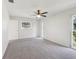 Bright bedroom with carpet floors, a ceiling fan, a sliding glass door, and plenty of natural light at 1605 W Dorchester Dr, Palm Harbor, FL 34684