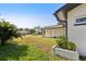 Home's exterior showcasing the well-maintained lawn and black-trimmed white paint at 1605 W Dorchester Dr, Palm Harbor, FL 34684