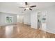 Bright living room with hardwood floors, ceiling fan, and open access to the kitchen at 1605 W Dorchester Dr, Palm Harbor, FL 34684