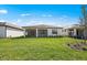 Backyard featuring a lush green lawn, new landscaping, and a view of neighboring homes at 1770 Pepper Grass Dr, North Port, FL 34289