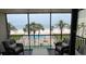 Screened balcony view of the community pool, beach, and ocean, with comfortable outdoor seating at 18304 Gulf Blvd # 309, Redington Shores, FL 33708