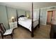 Bright bedroom with a four poster bed, dresser, and doorway leading to an en suite bathroom at 18304 Gulf Blvd # 309, Redington Shores, FL 33708