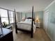 Cozy bedroom with a four poster bed, natural light and a view of the ocean at 18304 Gulf Blvd # 309, Redington Shores, FL 33708