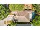 Aerial view showcases the home's layout with a private pool, roof, driveway, and lush landscaping at 19227 Garden Quilt Cir, Lutz, FL 33558