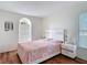Bright bedroom with a bed, two bedside tables, unique window and gleaming wood floors at 19227 Garden Quilt Cir, Lutz, FL 33558