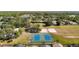 Aerial view of community tennis and volleyball courts within the neighborhood, surrounded by lush trees and homes at 19227 Garden Quilt Cir, Lutz, FL 33558