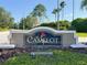 Elegant community sign reading 'Camelot' with a rose emblem, set against lush greenery at 19227 Garden Quilt Cir, Lutz, FL 33558