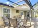 Outdoor covered patio seating and dining area next to pool with screened enclosure for bug-free entertaining at 19227 Garden Quilt Cir, Lutz, FL 33558