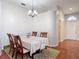Traditional dining room featuring a table set, decorative chandelier, with an entrance leading to the front entrance at 19227 Garden Quilt Cir, Lutz, FL 33558