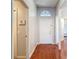 Inviting entryway with wood floors, alarm system, and natural light from a decorative window above the front door at 19227 Garden Quilt Cir, Lutz, FL 33558