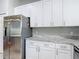 Well-lit kitchen highlighting modern stainless steel appliances, white custom cabinets, and granite countertops at 19227 Garden Quilt Cir, Lutz, FL 33558