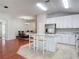 Spacious open-concept kitchen features stainless steel appliances, white cabinets, and granite countertops, with dining area adjacent at 19227 Garden Quilt Cir, Lutz, FL 33558