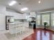 This open kitchen features white cabinets, stainless appliances, a center island, and hardwood floors at 19227 Garden Quilt Cir, Lutz, FL 33558