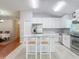 Spacious kitchen featuring stainless steel appliances, white cabinets, granite counters, and an island with seating at 19227 Garden Quilt Cir, Lutz, FL 33558