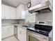 This kitchen features white cabinets, stainless steel appliances, granite countertops, and natural light at 19227 Garden Quilt Cir, Lutz, FL 33558