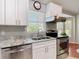 This bright kitchen has granite countertops, stainless steel appliances, and white cabinets next to a bay window at 19227 Garden Quilt Cir, Lutz, FL 33558