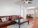 Bright living room boasts hardwood floors, leather furniture, and views into the dining room at 19227 Garden Quilt Cir, Lutz, FL 33558