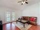 Cozy living room featuring a leather sofa, patterned rug, French doors to pool, and bright, vaulted ceiling at 19227 Garden Quilt Cir, Lutz, FL 33558
