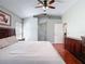 Main bedroom featuring wooden floors, ceiling fan, ample natural light, and access to hallways and ensuite bathroom at 19227 Garden Quilt Cir, Lutz, FL 33558