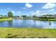 Scenic view of a tranquil pond with lush green lawns and neighboring homes, ideal for nature lovers at 19227 Garden Quilt Cir, Lutz, FL 33558