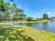 Lakeside property with a tranquil pond view, complemented by mature trees and well-kept lawns at 19227 Garden Quilt Cir, Lutz, FL 33558