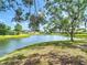 Picturesque pond surrounded by well-maintained lawns and mature trees, creating a serene and inviting landscape at 19227 Garden Quilt Cir, Lutz, FL 33558