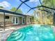 Inviting pool with step entry in screened enclosure offering seamless indoor-outdoor living and relaxation space at 19227 Garden Quilt Cir, Lutz, FL 33558