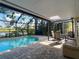 Screened-in pool area overlooking lush landscaping and a tranquil lake, with covered seating areas at 19227 Garden Quilt Cir, Lutz, FL 33558