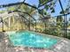 Beautiful backyard pool with screened enclosure overlooking a serene lake and lush landscaping and brick paver surround at 19227 Garden Quilt Cir, Lutz, FL 33558