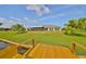 Expansive backyard with lush lawn, palm trees, and a dock at 2003 Wedge Ct, Sun City Center, FL 33573