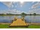 Wooden dock on the water with built in benches and tranquil water views at 2003 Wedge Ct, Sun City Center, FL 33573