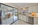 Bright kitchen with stainless steel appliances, granite countertops, and an adjacent sunroom with lake views at 2003 Wedge Ct, Sun City Center, FL 33573