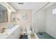 Bright bathroom featuring double sinks, modern fixtures, and a walk-in shower with decorative blue tile at 2250 64Th N St, St Petersburg, FL 33710