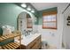 Cozy bathroom with wood vanity, vessel sink, modern faucet, arched mirror, and bamboo blinds at 2250 64Th N St, St Petersburg, FL 33710