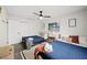 Bedroom featuring two twin beds with blue bedding, neutral walls, ceiling fan, and a large window at 2250 64Th N St, St Petersburg, FL 33710