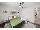 Bright bedroom featuring a large window, neutral walls, hardwood floors, ceiling fan, and modern lighting at 2250 64Th N St, St Petersburg, FL 33710