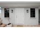 Neutral exterior featuring a white door and two flanking sconce lighting fixtures at 2250 64Th N St, St Petersburg, FL 33710